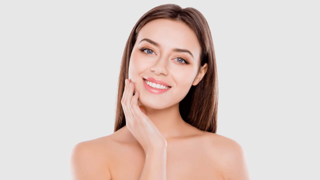 Beautiful young woman smiling with a hand on the face | EXION | Shahla Medical Group